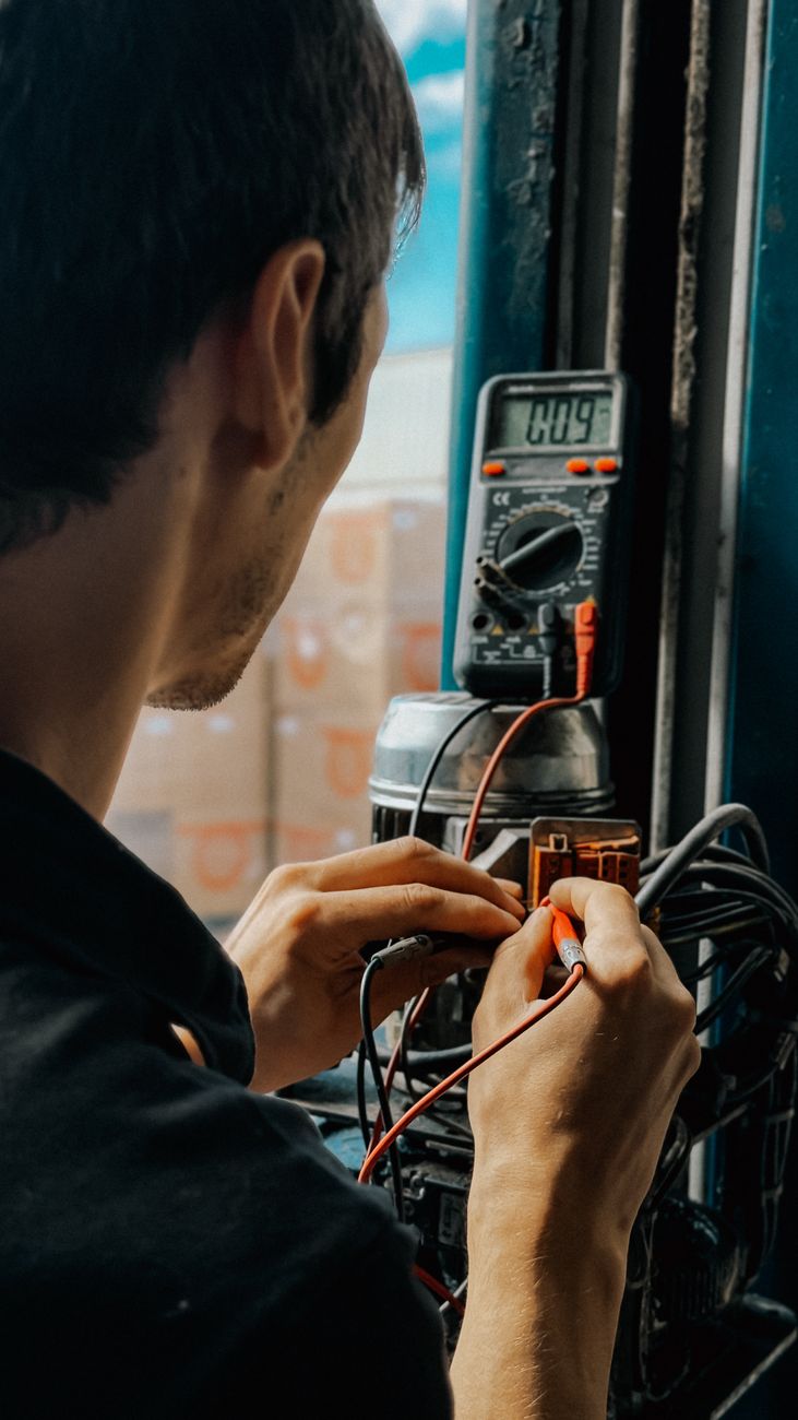 electrician working with multimeter in workshop